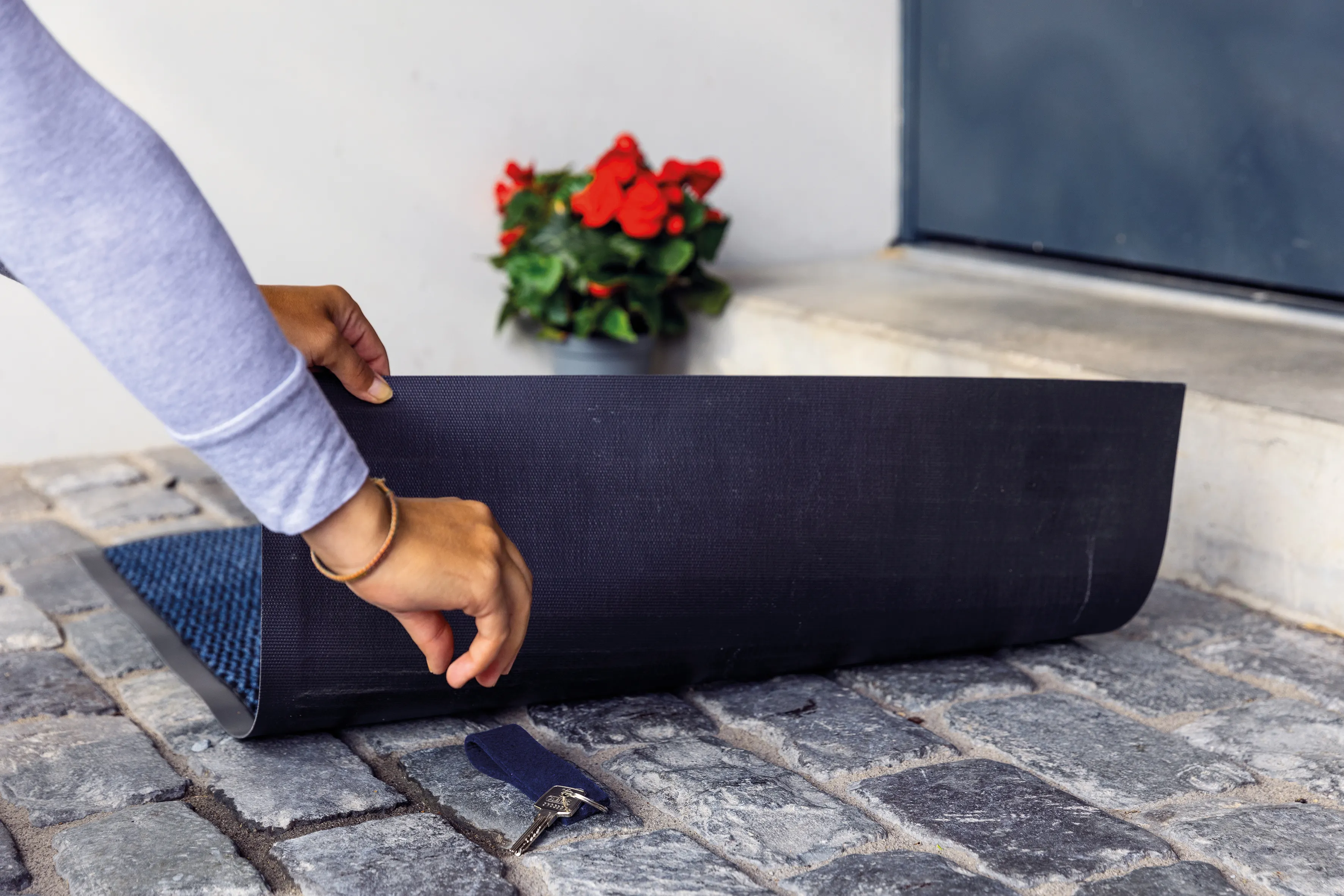 Das klassisches Schlüsselversteck, das jeder kennt – statt einen Ersatzschlüssel unter der Fußmatte zu verstecken, teilt man den Zugang lieber digital oder per Code.